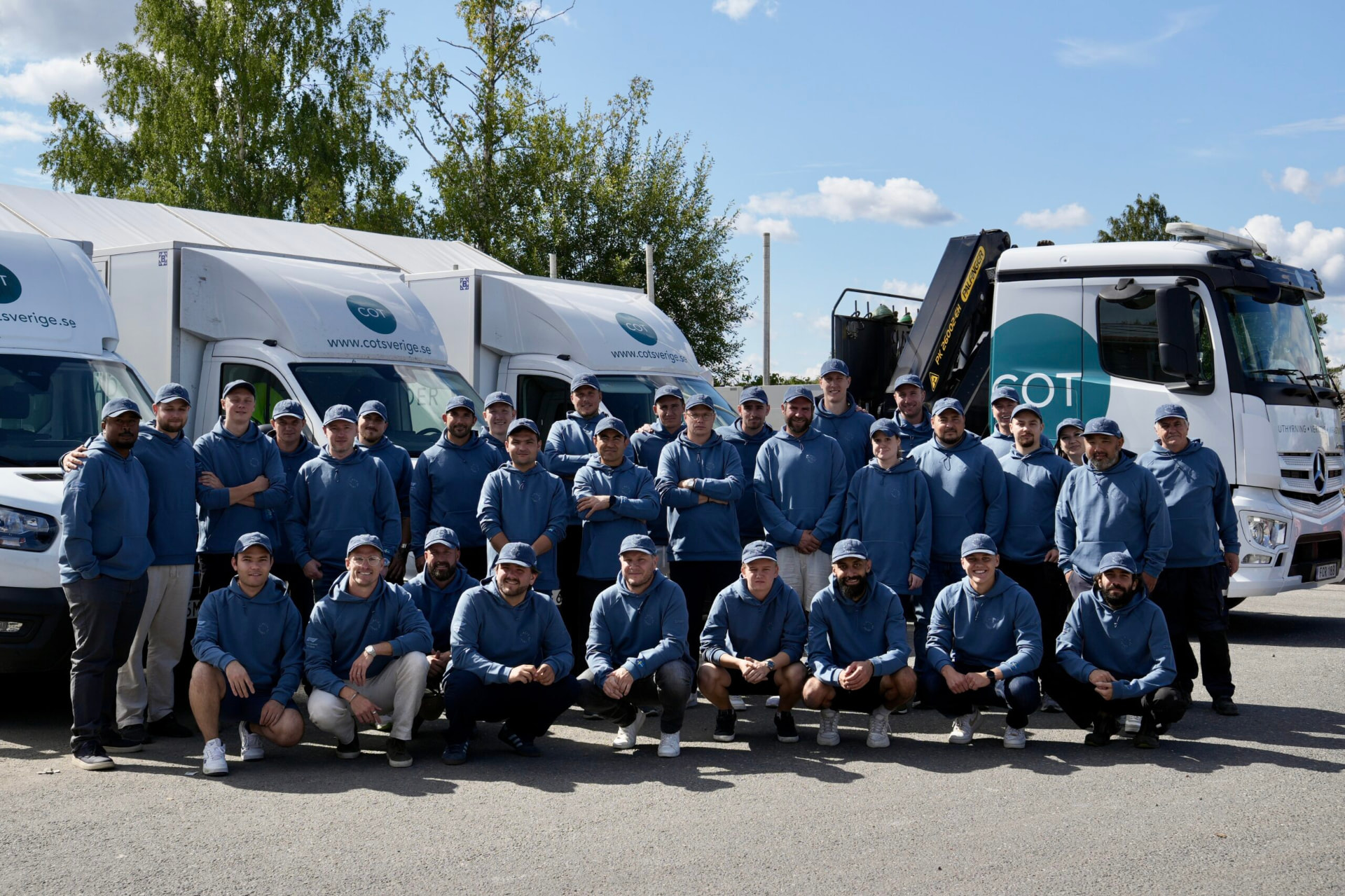 The COT Sverige team standing together in front of the company fleet